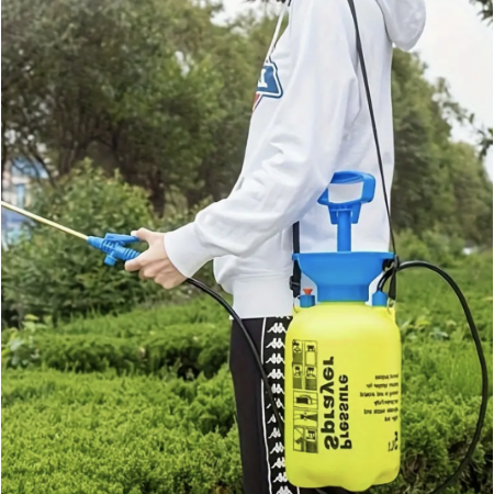 5L Pressure Sprayer with carry strap in use - person spraying garden hedges